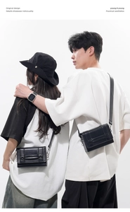 Detail view of two black square crossbody bags with glossy finish and buckle straps