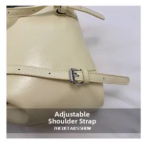 Close-up of adjustable cream leather shoulder strap with silver buckle and fine stitching