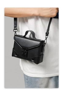 Detail of a vintage box crossbody bag with metal buckle and matte leather texture