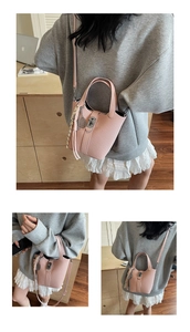 Detailed view of pink woven bucket bag with tennis racket charm and striped silk scarf