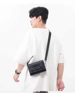 Macro detail of black leather crossbody bag featuring classic boxy shape and fine stitching