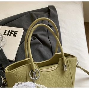Détail du sac cabas vert clair en cuir grainé avec ferrures argentées et breloque perle
