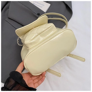Close-up of cream quilted faux leather backpack showing bottom width and side details