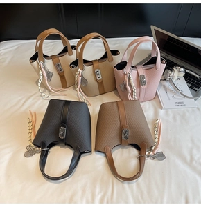 Close-up of textured woven bucket bags in five colors with metallic lock and tennis charm