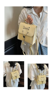 Detail of yellow patent leather backpack with pearl butterfly pendant and metal chains