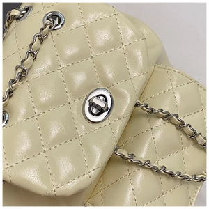 Macro shot of quilted faux leather texture with silver twist lock and chain detail