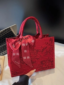 Red bridal tote bag with floral jacquard and silk ribbon in a modern office setting