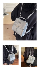 Detailed back view of a silver metallic backpack with pearl charms and lace-up design
