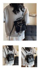 Detail of trendy black backpack featuring a metal bow, pearl charm, and lace-up design