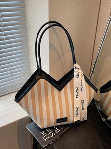 Minimalist striped canvas tote bag with black leather handles and decorative scarf