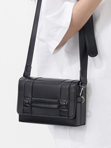 Minimalist black faux leather rectangular crossbody bag with decorative rivets and wide strap