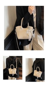 Vue détaillée d'un sac cabas beige grainé avec un charm décoratif en dentelle et perles
