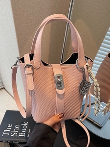 Pink woven bucket handbag with silver lock and detachable strap in a fashion set