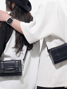 Chic black leather rectangular crossbody bag with silver buckle shown on models