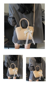 Détail du sac cabas kaki clair à grain galet avec pendentif nœud en dentelle et perle