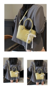 Détail du cabas vert clair en cuir grainé avec nœud en dentelle et pendentif perle