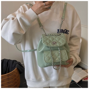 Close-up of light green quilted bucket bag with silver metal twist lock and chain strap