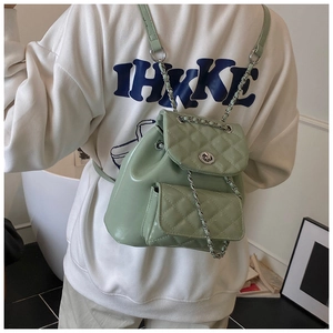 Macro shot of light green quilted leather mini backpack with silver chain and twist lock