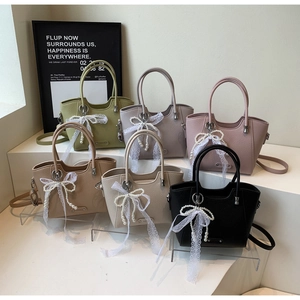 Détail de sacs fourre-tout colorés avec nœuds en dentelle perlée et texture lychee