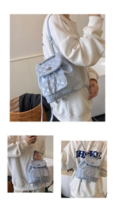 Detail of light blue quilted leather backpack with glossy finish and chain straps