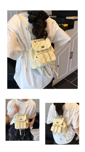 Detailed macro view of cream yellow quilted backpack with silver chain straps and flap closure