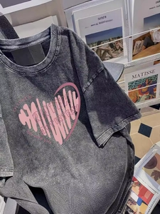 Oversize washed grey t-shirt with artistic pink heart print in creative studio setting