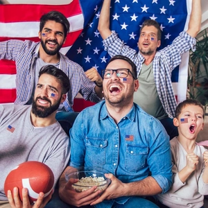 People wearing American flag stickers on cheeks while celebrating during a sports game