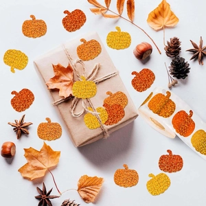 Close-up of orange and yellow glitter pumpkin stickers on a festive autumn gift package
