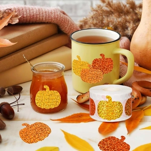 Glitter pumpkin stickers on glass jars in a warm autumn setting with falling leaves