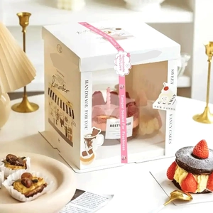 White bakery gift box with pink ribbon and window showing handmade scented candles