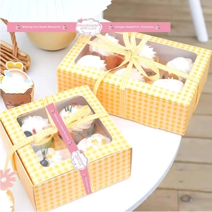 Roll of pink handmade with love stickers sealing a white and yellow checkered food box