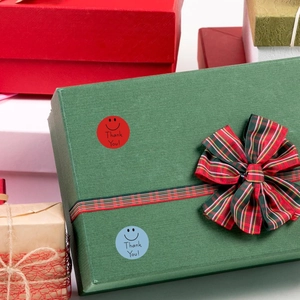 Close-up of Thank You smiley face stickers on a gift box for packaging decoration