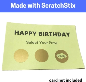 Macro detail of gold scratch-off stickers on a birthday card with partially revealed dinner prize