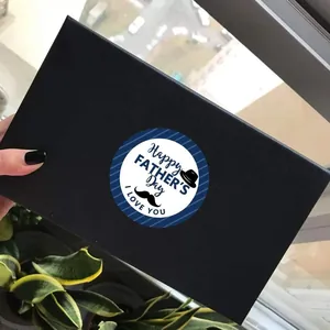 Father's Day sticker on black gift box with Happy Father's Day greeting and hat icon
