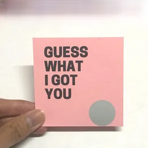Detail of pink card featuring a round silver scratch-off sticker and printed text