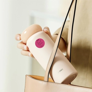 Close-up of pink round smile face sticker on a minimalist beige thermos cup in a bag