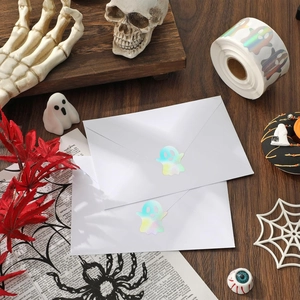 Close-up of holographic ghost seal stickers on an envelope with Halloween decor