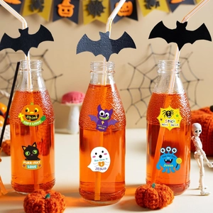 Macro detail of Halloween religious stickers with cartoon pumpkins and ghosts on a glass jar