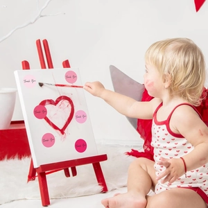 Child uses warm-toned Thank You stickers to decorate a drawing board in a creative scene