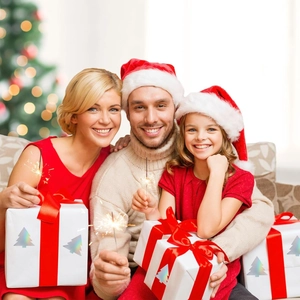 Close-up of holographic Christmas tree stickers on white gift boxes with red ribbon bows