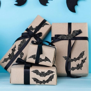 Close-up of black glitter bat stickers used for sealing Halloween gift boxes