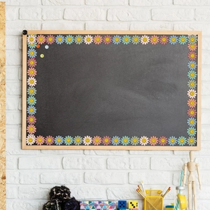 Detail of sunflower border stickers with smiley faces on a classroom chalkboard