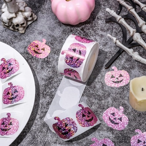 Pink glitter Halloween pumpkin sticker roll with festive decorations on dark background