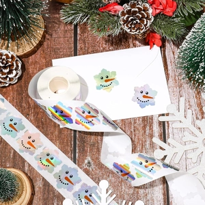 Close-up of holographic snowflake snowman stickers on a festive wooden tabletop setup