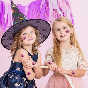Detail of glitter pink pumpkin face stickers applied to a child's face and hands