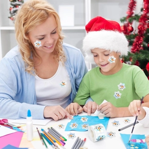 Close-up of holographic snowman stickers on a roll for festive Christmas DIY crafts