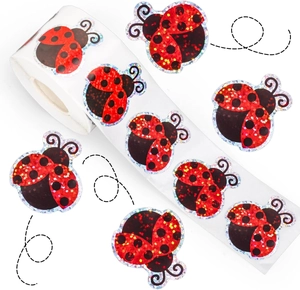 Macro detail of ladybug laser stickers with holographic glitter finish on a white roll