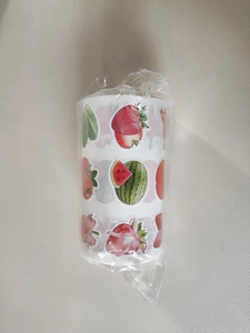 Macro shot of 1000 pieces fruit themed sticker roll in transparent plastic packaging