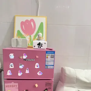 Autocollants d'Halloween holographiques avec fantômes sur la surface d'un mini frigo rose