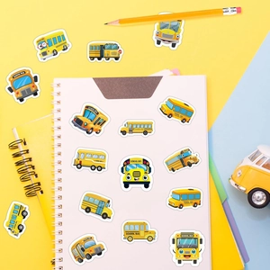 Detailed view of yellow cartoon school bus stickers on notebook and stationery backdrop